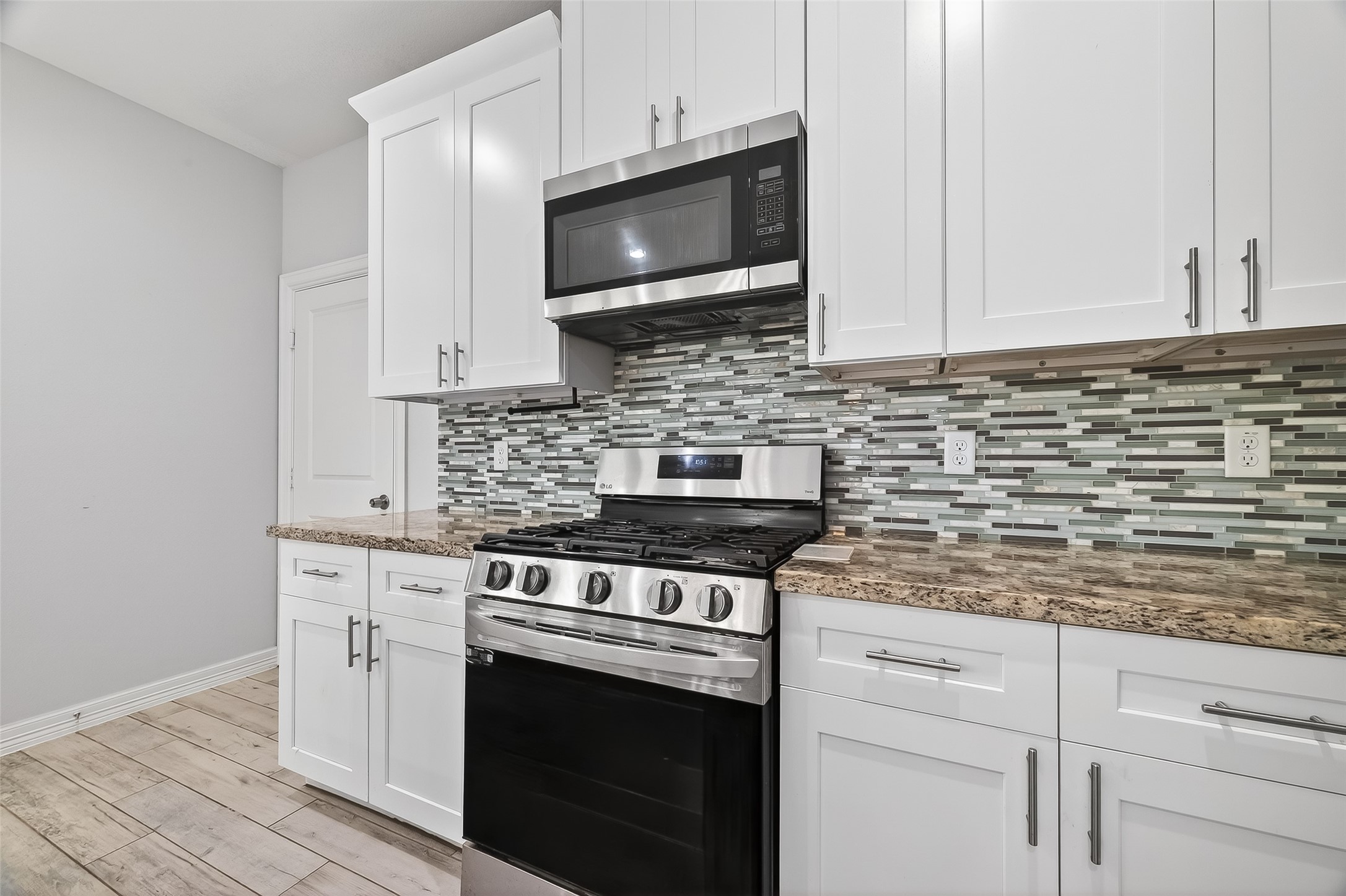 1411 Featherstone Street, Unit B Houston, TX 77020 - Photo 13 of 32 a kitchen with stainless steel appliances granite countertop white cabinets a stove a sink and dishwasher