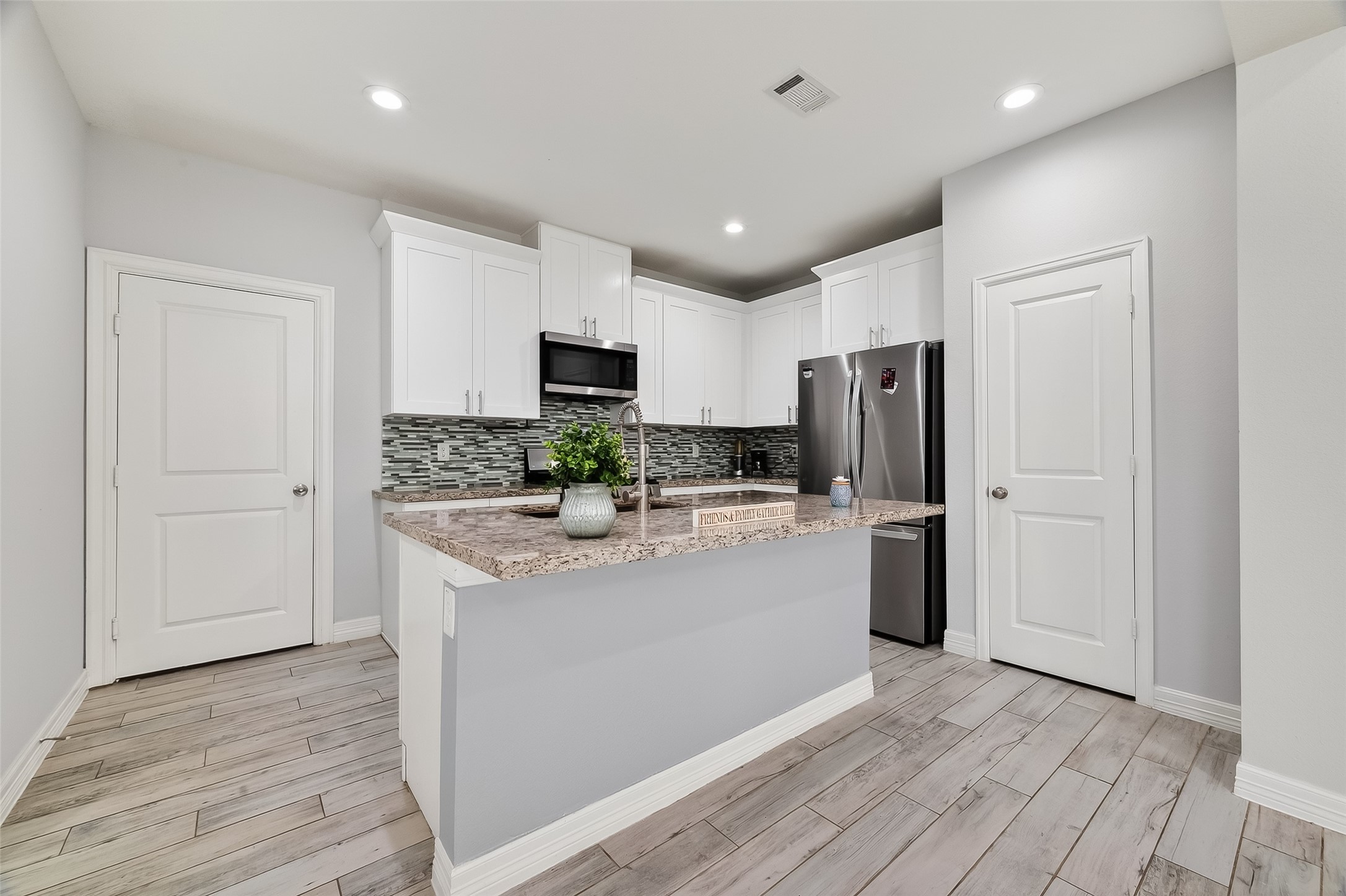 1411 Featherstone Street, Unit B Houston, TX 77020 - Photo 16 of 32 a kitchen with kitchen island a refrigerator sink and cabinets