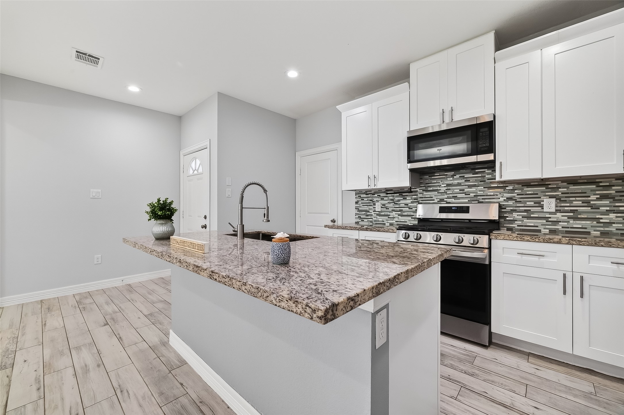 1411 Featherstone Street, Unit B Houston, TX 77020 - Photo 9 of 32 a kitchen with stainless steel appliances granite countertop a sink stove and cabinets
