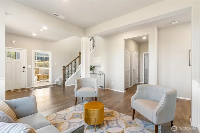a living room with furniture and a wooden floor