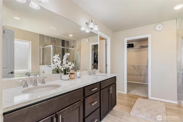 a bathroom with double vanity sinks and a mirror