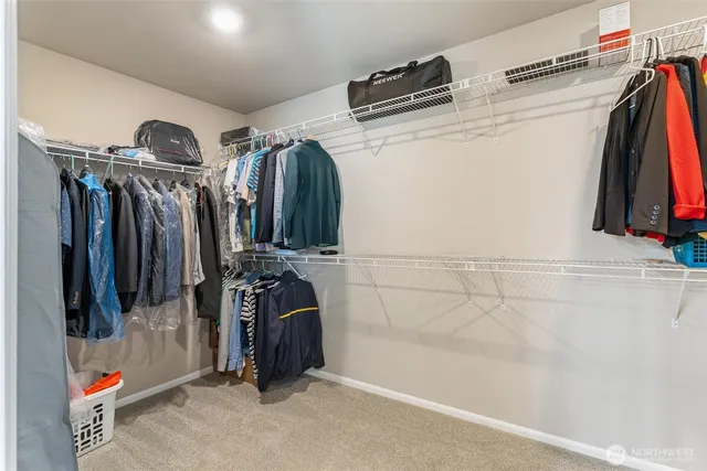 a view of walk in closet with clothes