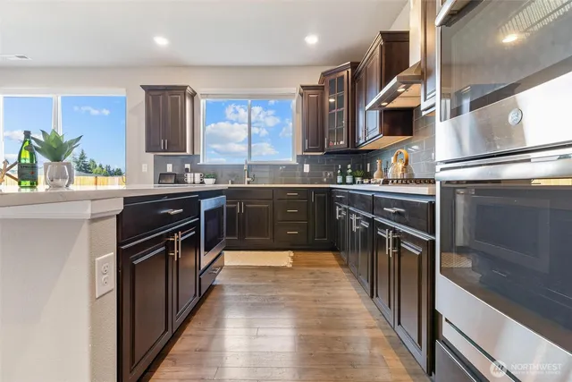 a kitchen with stainless steel appliances granite countertop a sink a stove and a refrigerator