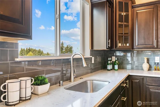 a kitchen with a granite countertop sink a potted plant and a window