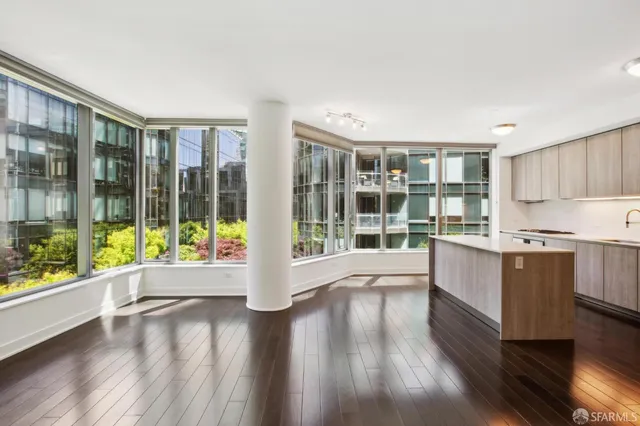 a large white kitchen with sink and large window