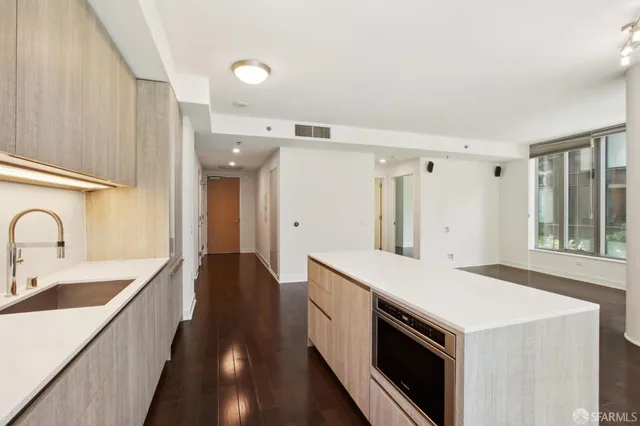 a view of a kitchen with a sink and wooden floor