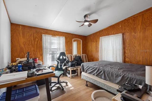 a bedroom with a bed gym equipment and a large window