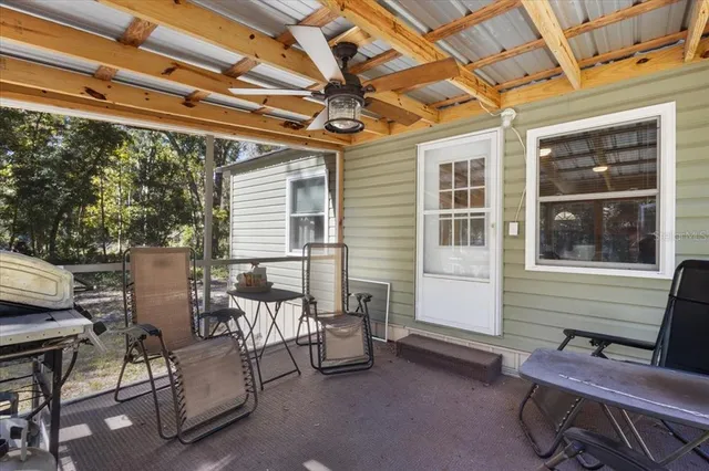 a view of a chairs and table in the back yard of the house