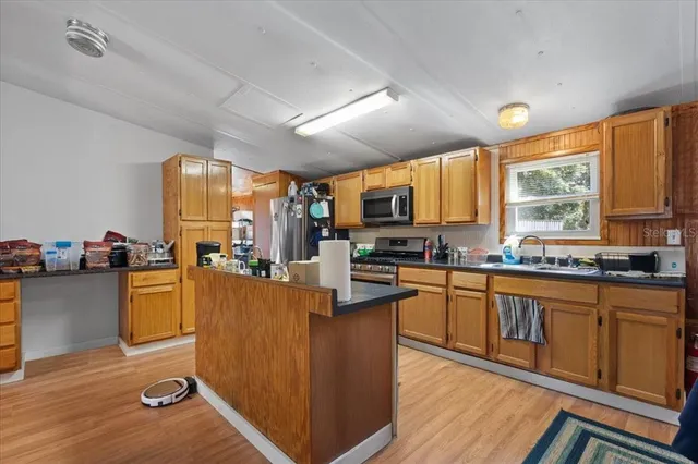 a kitchen with a sink appliances cabinets and dining table