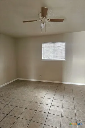 a view of a kitchen with white walls and a window