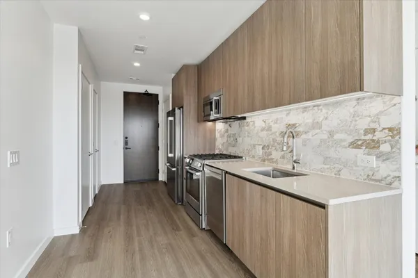a kitchen with stainless steel appliances granite countertop a sink stove and refrigerator