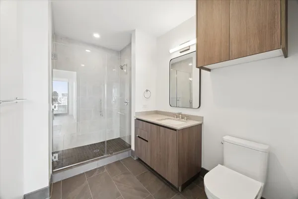a bathroom with a granite countertop sink mirror vanity and toilet