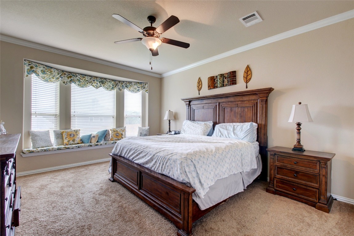 2004 Autumn Run Lane Round Rock, TX 78665 - Photo 15 of 35 a bedroom with a large bed and a chandelier fan