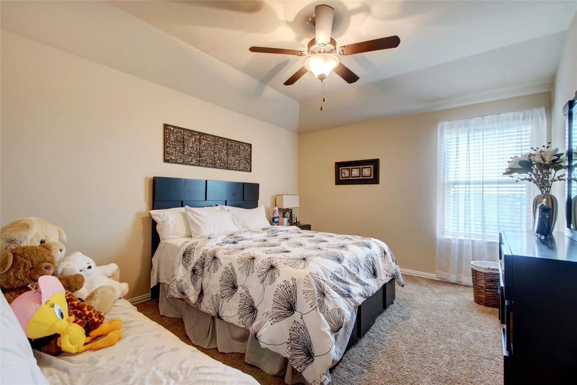 2004 Autumn Run Lane Round Rock, TX 78665 - Photo 20 of 35 a bedroom with a large bed and a chandelier