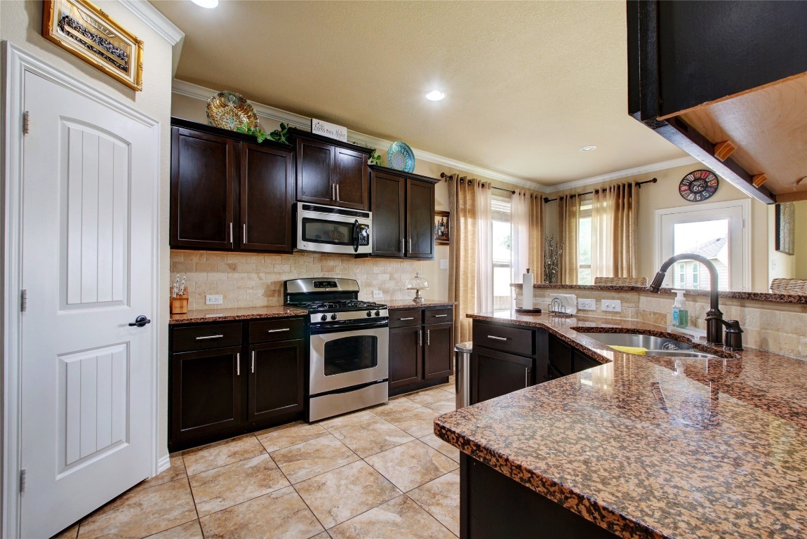 2004 Autumn Run Lane Round Rock, TX 78665 - Photo 7 of 35 a kitchen with kitchen island granite countertop stainless steel appliances stove microwave refrigerator and sink