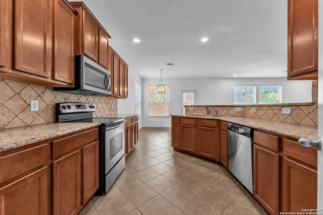 a kitchen with granite countertop cabinets stainless steel appliances and wooden cabinets