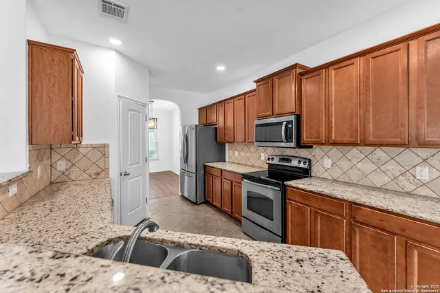 a kitchen with granite countertop a sink and cabinets