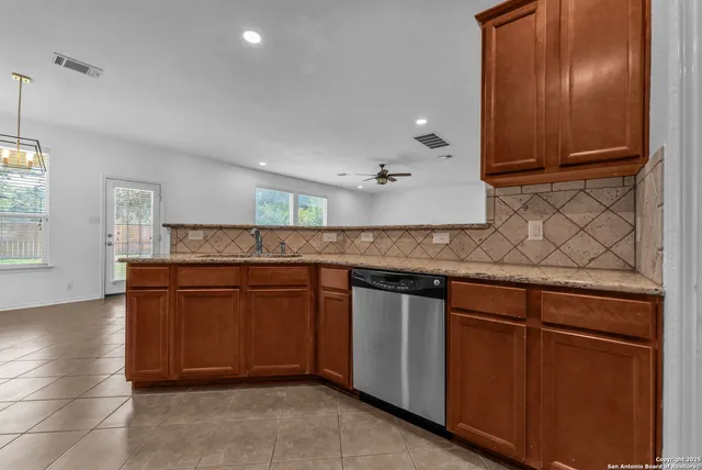 a kitchen with granite countertop wooden cabinets and stainless steel appliances
