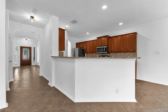 an empty room with wooden floor windows and cabinet