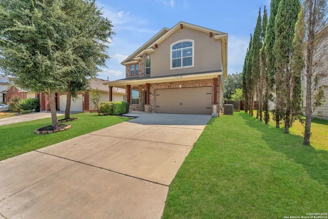a front view of a house with a yard and trees
