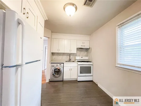 a kitchen with a refrigerator a stove and a window