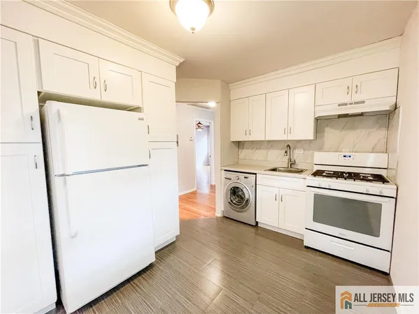a kitchen with a refrigerator sink stove and cabinets