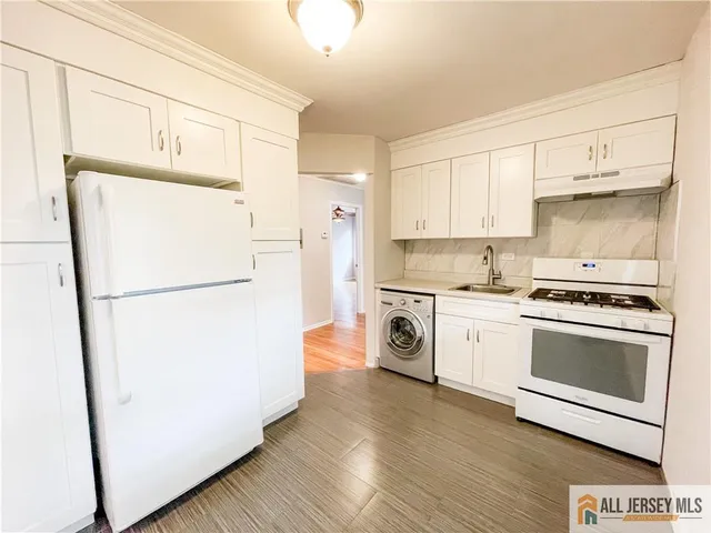 a kitchen with a refrigerator sink stove and cabinets