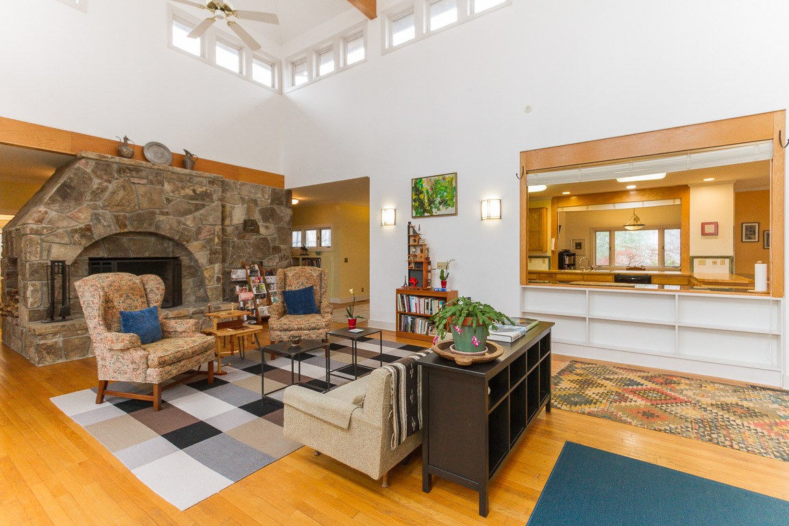 1033 Eva Lake Road Sewanee, TN 37375 - Photo 13 of 49 a living room with couches a fireplace and a dining table with wooden floor