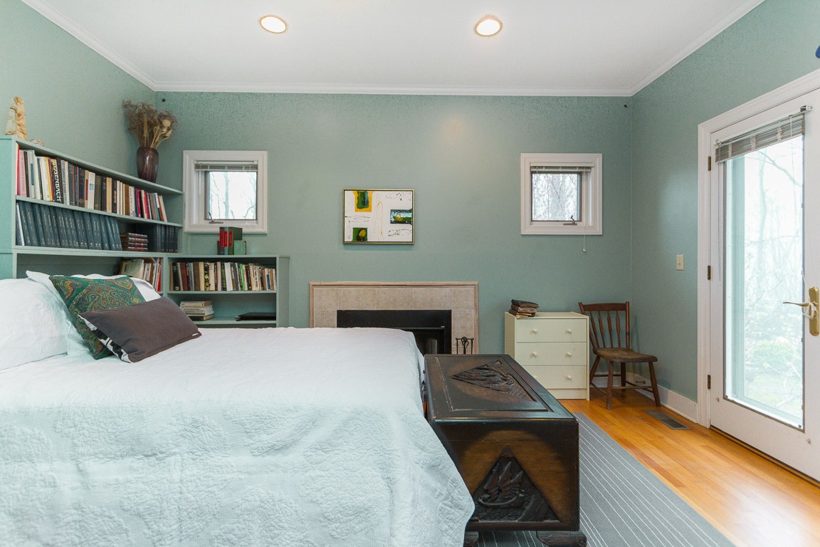 1033 Eva Lake Road Sewanee, TN 37375 - Photo 26 of 49 a bedroom with a bed next to a window with a bookshelf