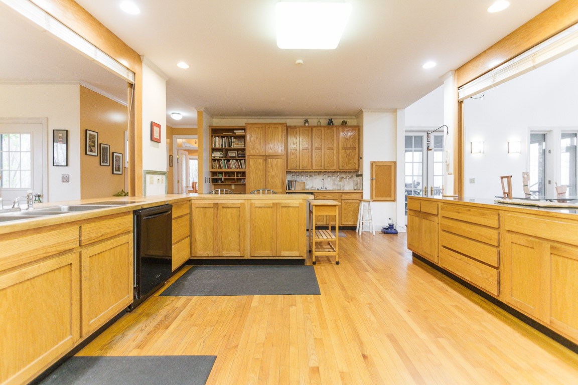1033 Eva Lake Road Sewanee, TN 37375 - Photo 6 of 49 a large white kitchen with wooden floors and stainless steel appliances