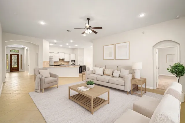 a living room with furniture kitchen view and a chandelier