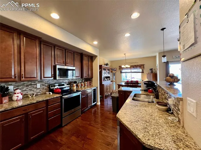 a kitchen with stainless steel appliances granite countertop sink stove top oven and cabinets
