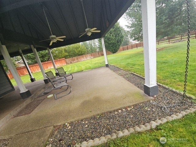502 366th St Court South Roy, WA 98580 - Photo 3 of 25 a view of a backyard with table and chairs under an umbrella