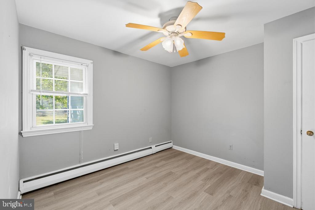 1326 Perrys Corner Road Grasonville, MD 21638 - Photo 21 of 35 an empty room with wooden floor and windows