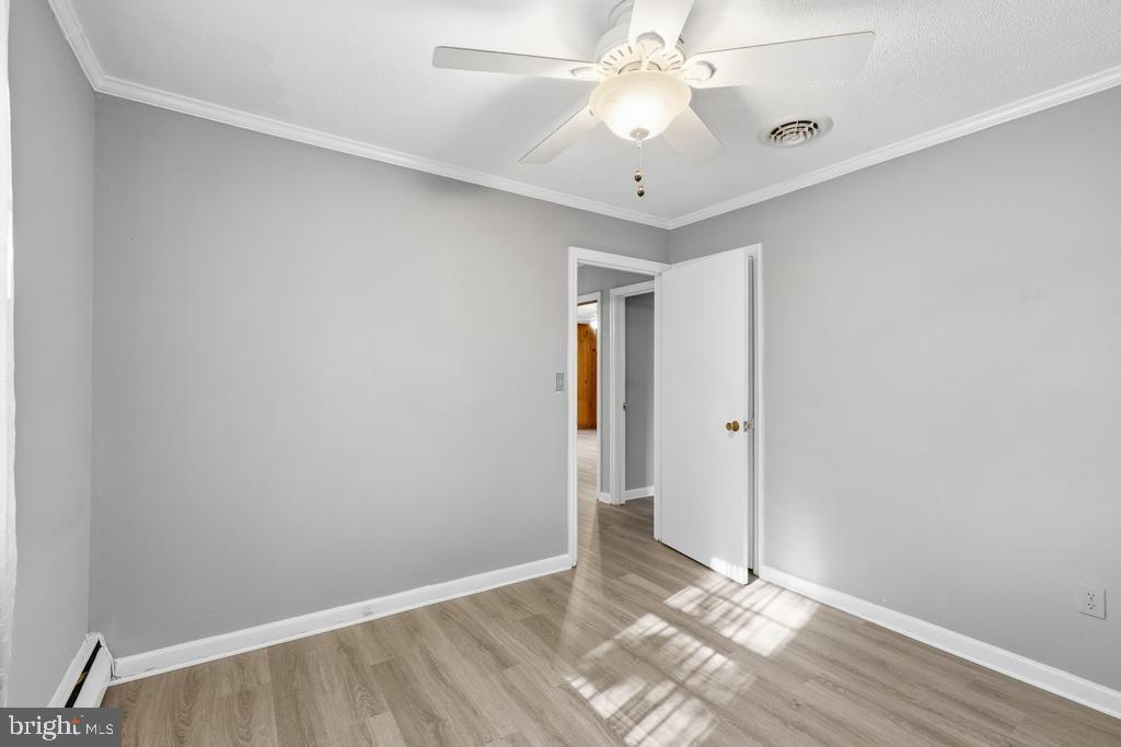 1326 Perrys Corner Road Grasonville, MD 21638 - Photo 25 of 35 an empty room with wooden floor and ceiling fan