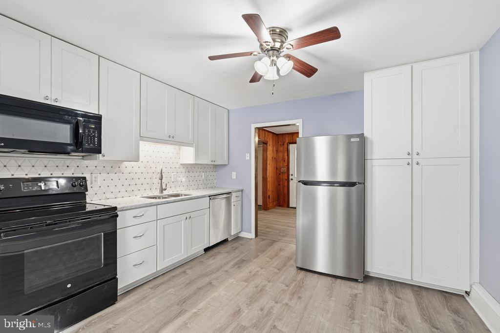 1326 Perrys Corner Road Grasonville, MD 21638 - Photo 3 of 35 a kitchen with a refrigerator a stove top oven a sink and cabinets