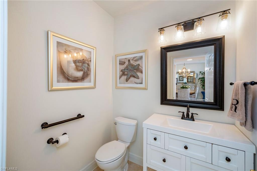 6012 Fairway Court Naples, FL 34110 - Photo 11 of 38 a bathroom with a toilet sink and mirror