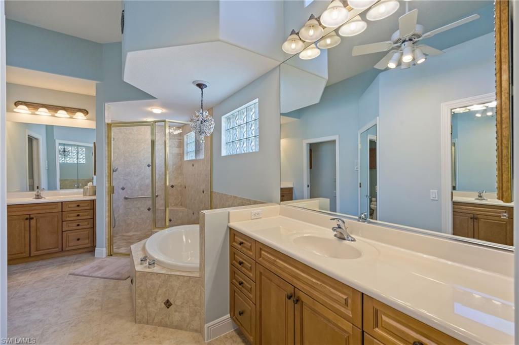 6012 Fairway Court Naples, FL 34110 - Photo 14 of 38 a spacious bathroom with a granite countertop sink a toilet a mirror a vanity and shower