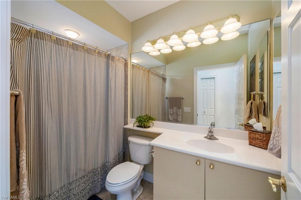 6012 Fairway Court Naples, FL 34110 - Photo 20 of 38 a bathroom with a sink a toilet and a mirror
