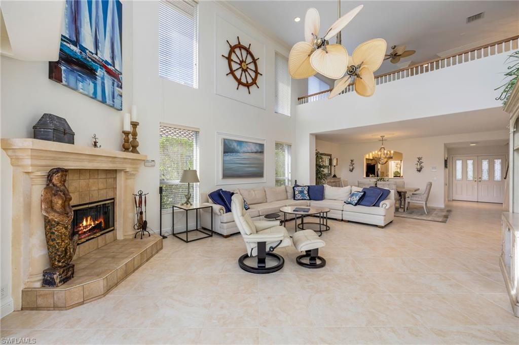 6012 Fairway Court Naples, FL 34110 - Photo 5 of 38 a living room with furniture and a fireplace