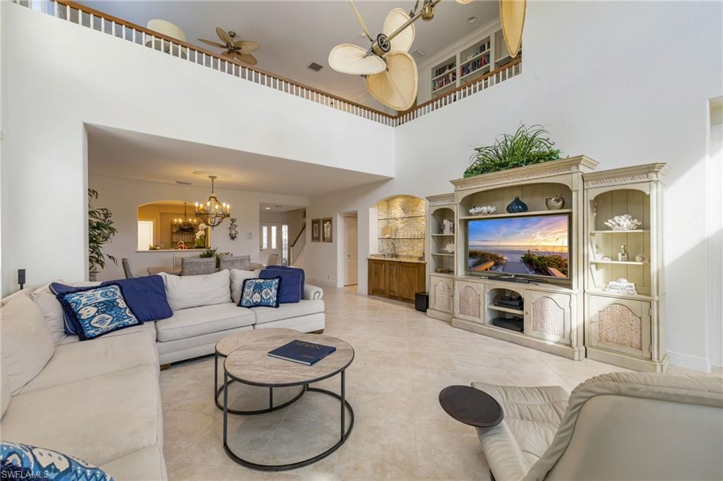 6012 Fairway Court Naples, FL 34110 - Photo 6 of 38 a living room with furniture and a flat screen tv