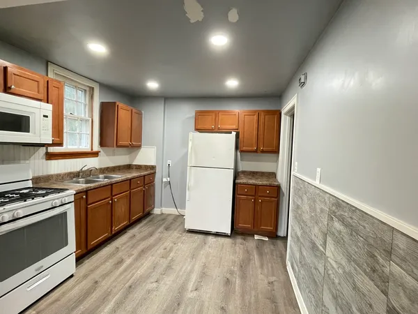 a kitchen with granite countertop stainless steel appliances refrigerator stove microwave and cabinets