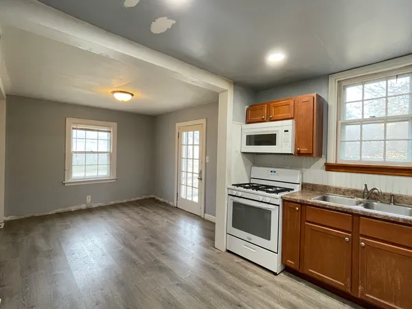 a kitchen with wooden floors appliances and window