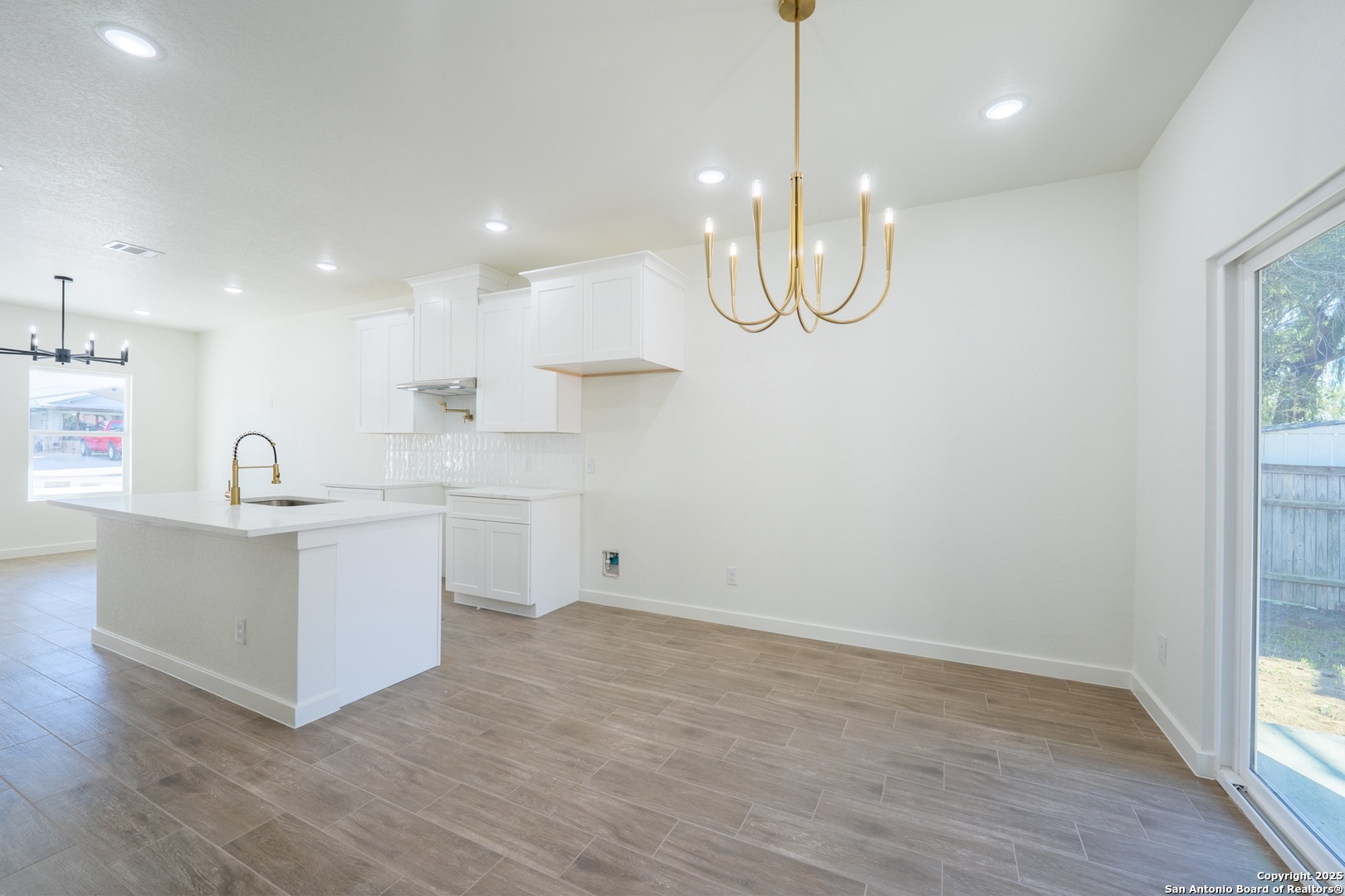20035 Morrison Street Somerset, TX 78069 - Photo 11 of 25 a kitchen with white cabinets and wooden floor