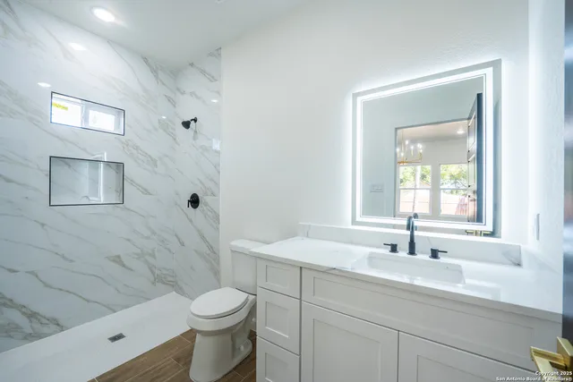 a bathroom with a sink toilet and shower