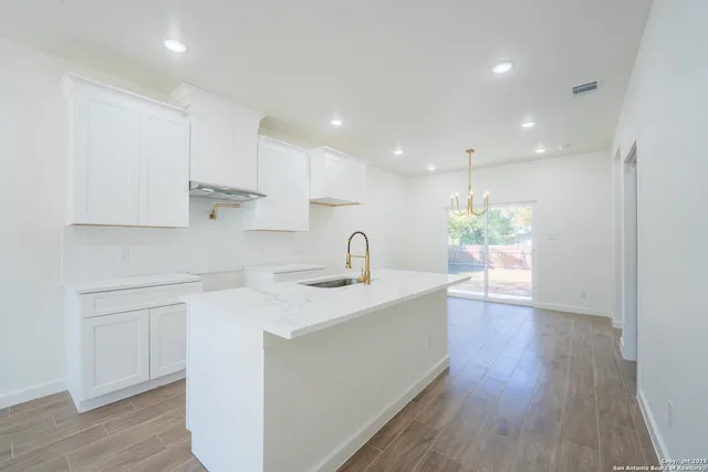 a view of kitchen with sink refrigerator and window