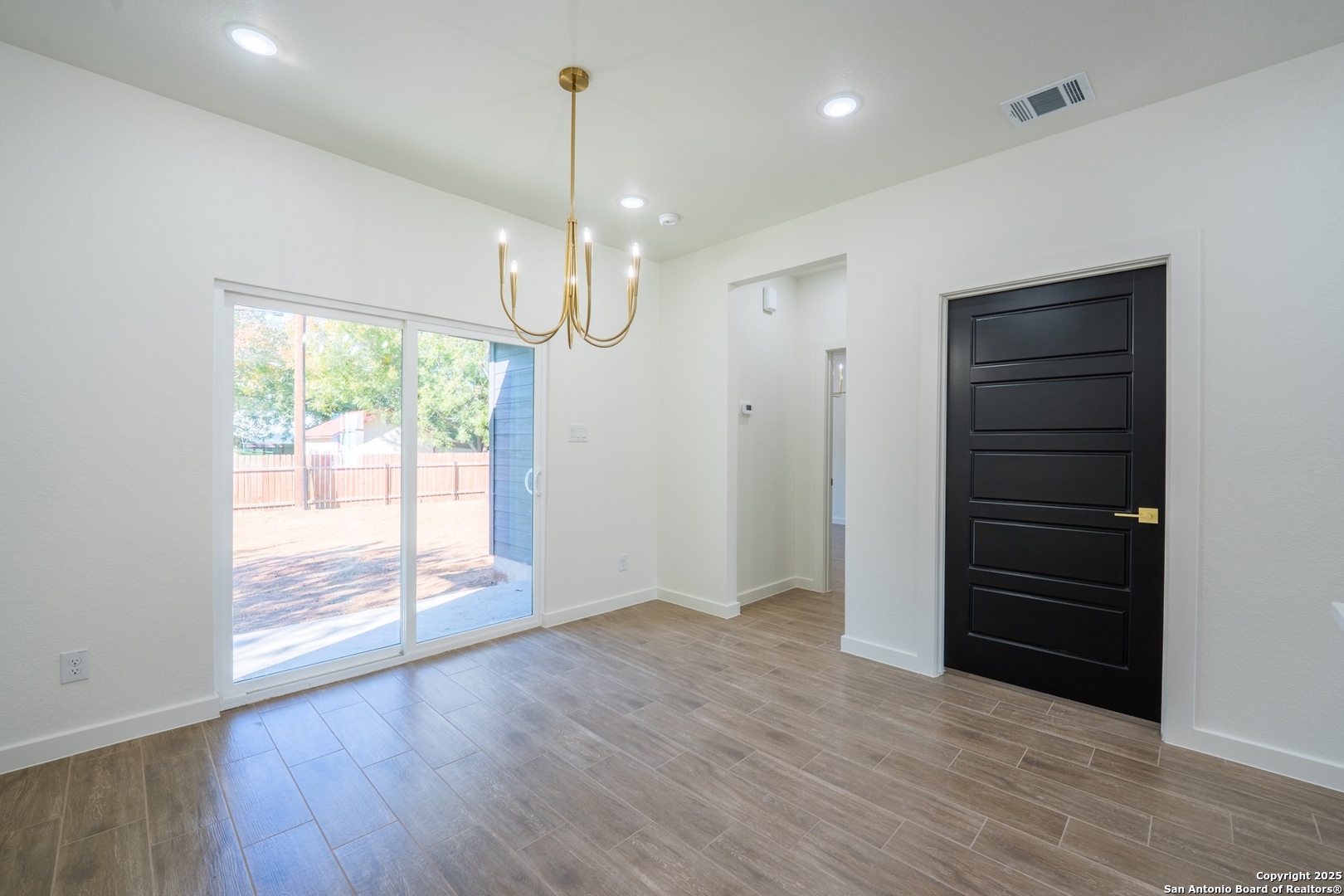 20035 Morrison Street Somerset, TX 78069 - Photo 9 of 25 an empty room with wooden floor cabinet and windows