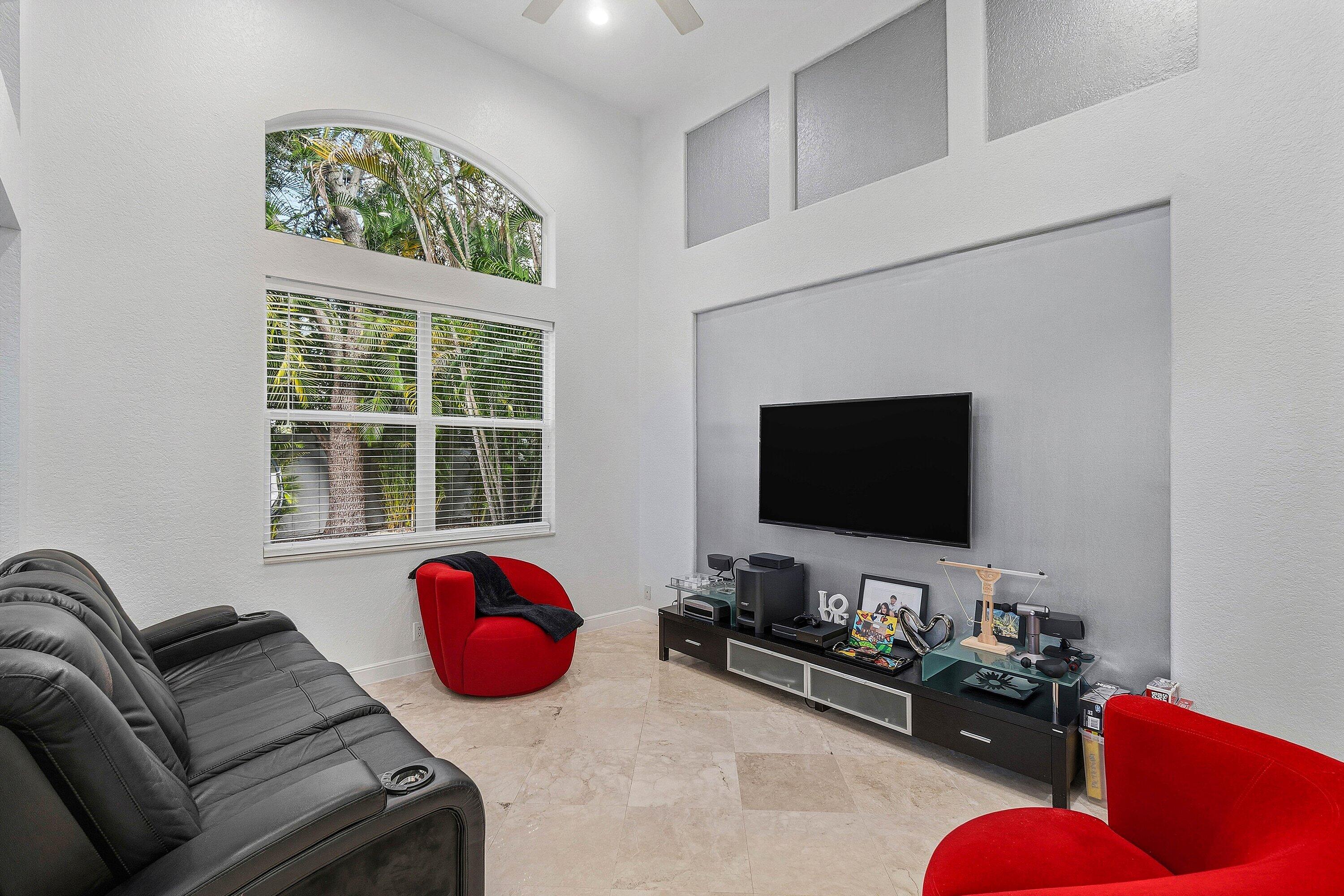 2358 Northwest 49th Lane Boca Raton, FL 33431 - Photo 19 of 47 a living room with furniture a flat screen tv and a floor to ceiling window