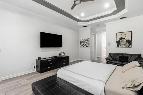 a spacious bedroom with a bed and a flat screen tv