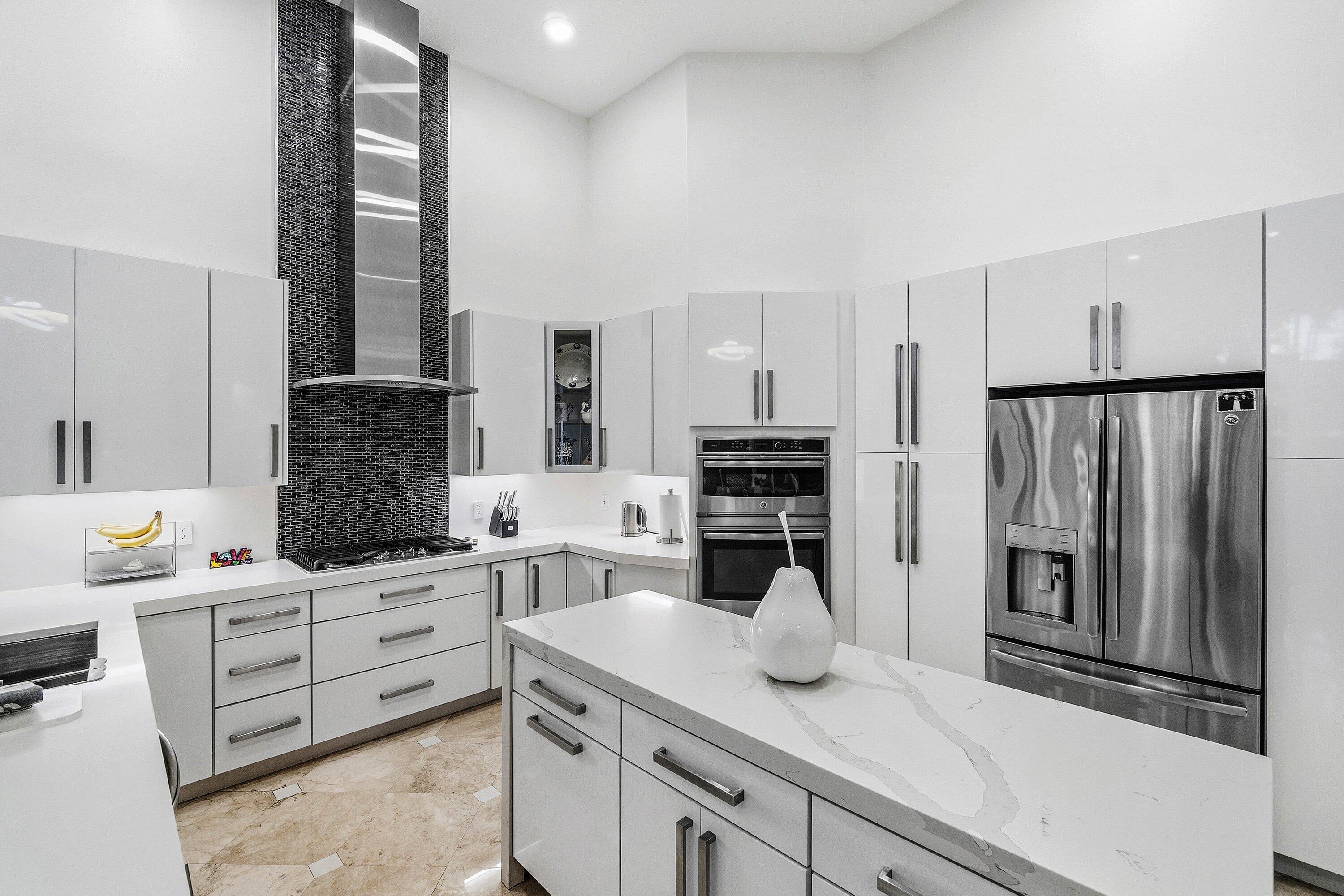 2358 Northwest 49th Lane Boca Raton, FL 33431 - Photo 4 of 47 a kitchen with stainless steel appliances kitchen island granite countertop a refrigerator and cabinets